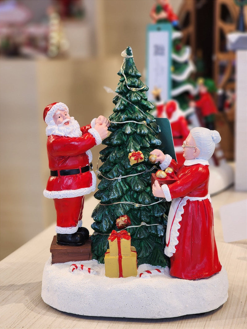 CENÁRIO VILA NATALINA PAPAI E MAMÃE NOEL MONTANDO A ÁRVORE 28CM  - PRÉ VENDA 2025